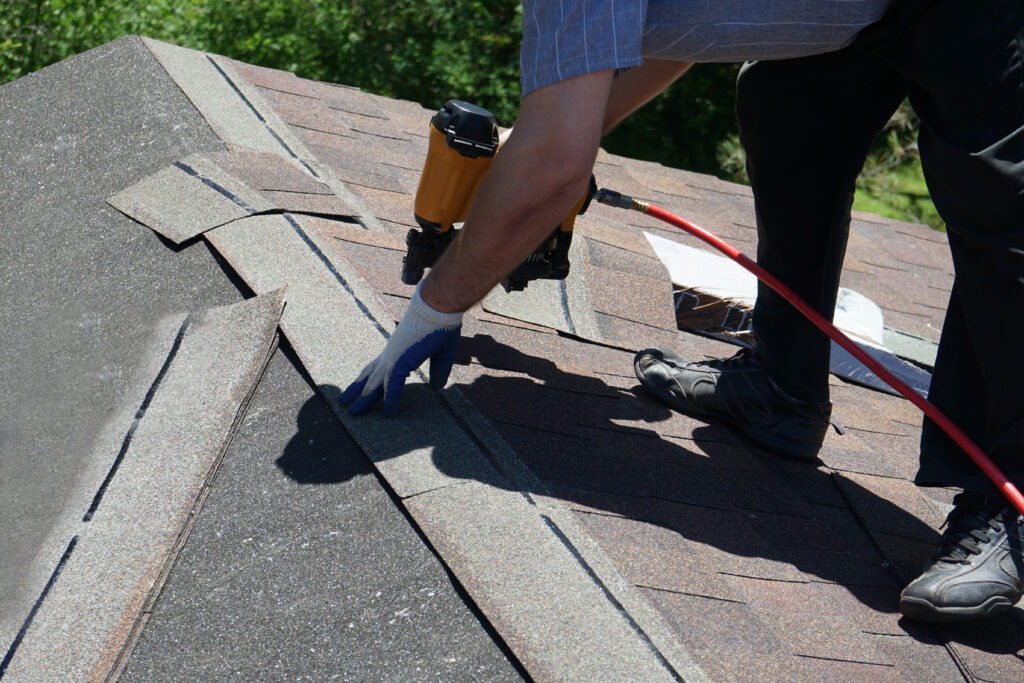 Man replacing shingle roof