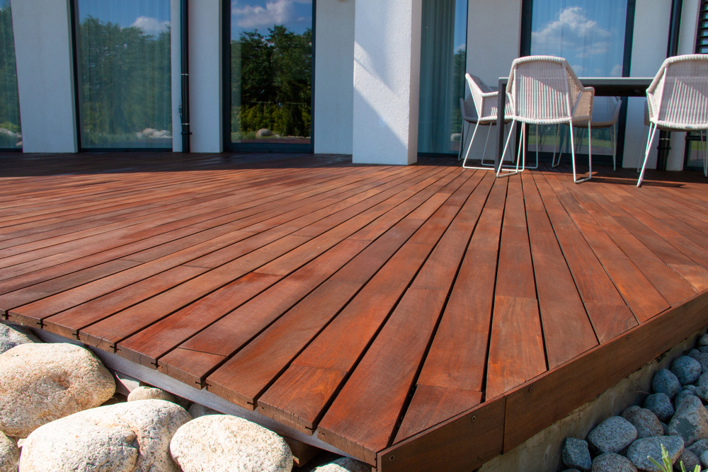 hardwood decks space outdoors with dark wood and white chairs with rocks around