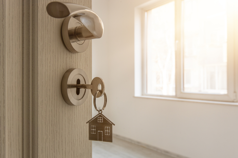 turning key into door in new home after buying and moving in to new town and waiting to do renovations and remodels