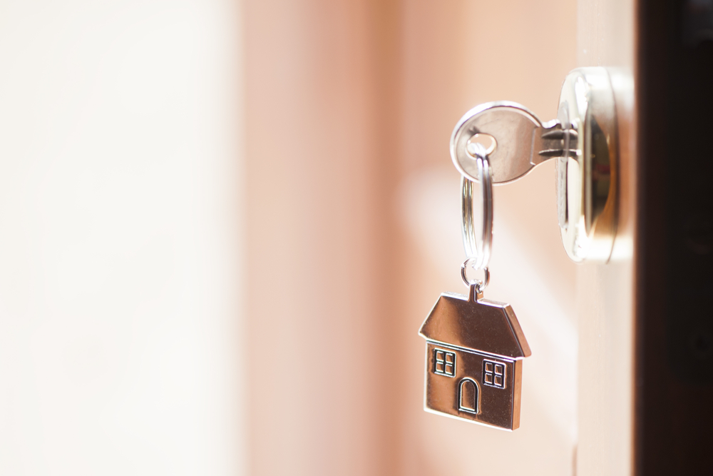 putting key into front door of new home to renovate different areas of house to remodel