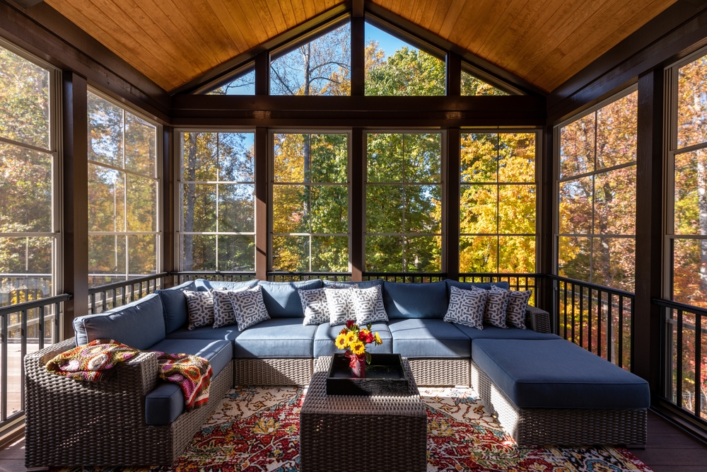 Screened porch during the fall season with rays of sunlight coming through the windows