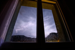 severe weather storm outside of window of home protected by impact resistant glass and protective technology