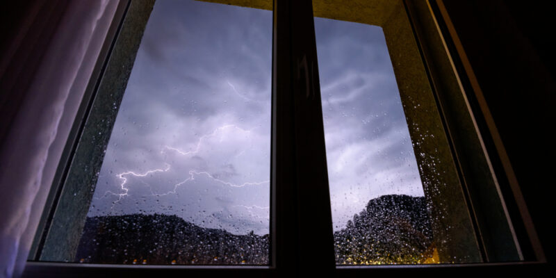 severe weather storm outside of window of home protected by impact resistant glass and protective technology