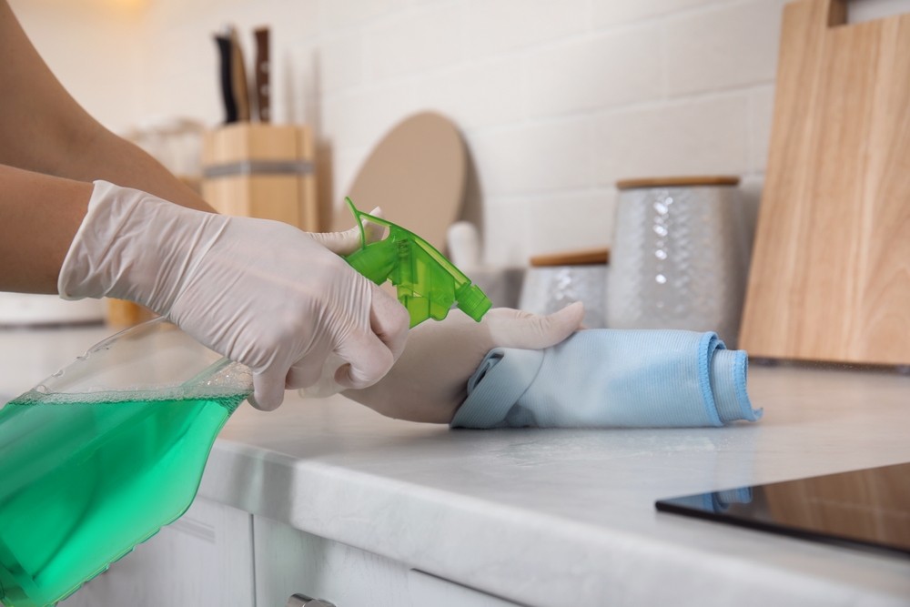 cleaning a kitchen countertop after choosing the best type of material for family with kids