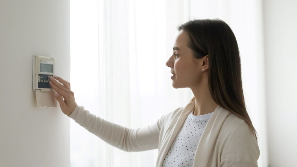 A woman adjusting her home AC system