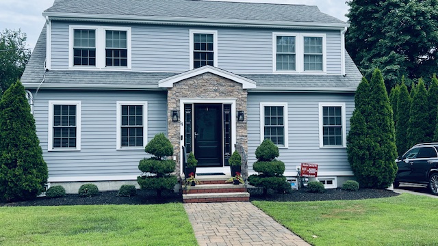 everlast siding in seaside grey with stone facade on front in pocono autumn installation for home in norwood massachusetts by three sons window and door