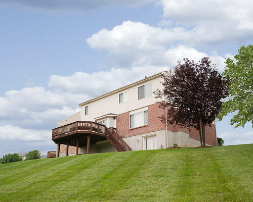 deck on sloped backyard of home with contracting and landscaping using custom deck services from a professional