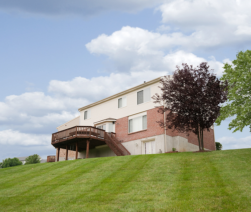 deck on sloped backyard of home with contracting and landscaping using custom deck services from a professional