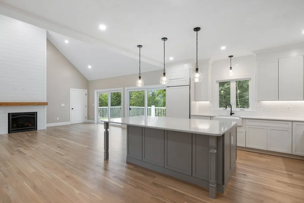 Open-concept white kitchen with gray island and living area