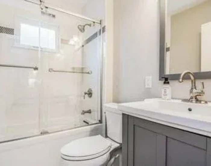 Bathroom remodel with gray vanity and white tile shower