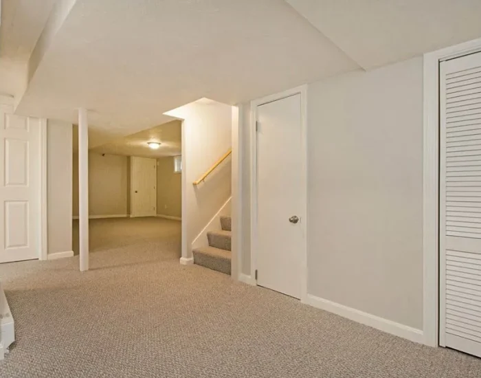 Finished basement living space with carpeted stairs
